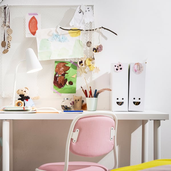 Childs desk with TJABBA pink filing folders, drawings, and supplies.