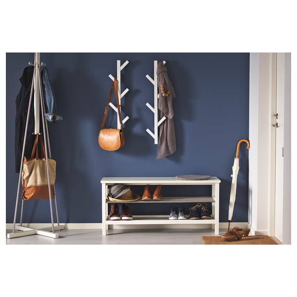 Blue wall with TJUSIG storage: coat rack, shoe bench, umbrella, doormat.