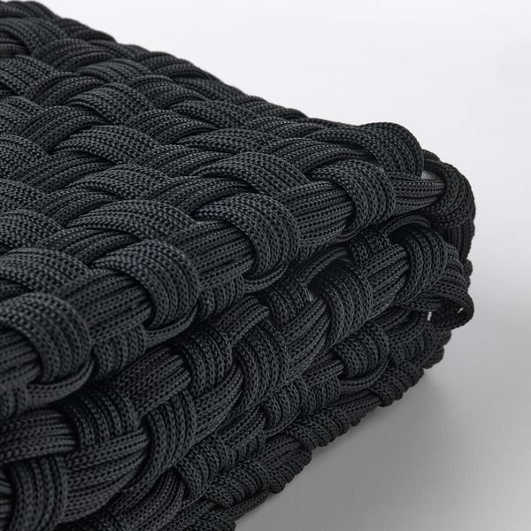 Braided black rope cushion cover, intricately woven, displayed on a light background, showcasing high-quality craftsmanship.
