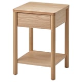 The TONSTAD bedside table is light brown, square-shaped with rounded legs, featuring a single drawer and bottom shelf in oak wood veneer.