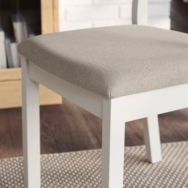 Cushioned chair seat with soft fabric, angled legs for stability.