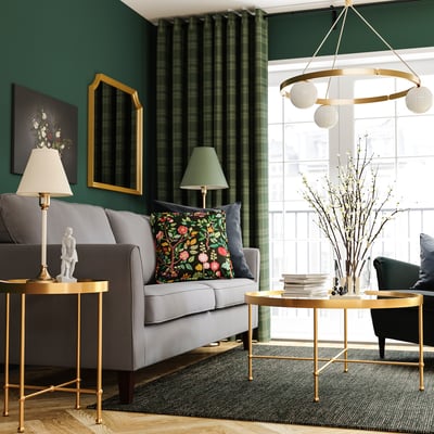 Stylish living room with grey sofa, gold accents, and green curtains.