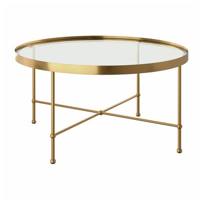 A TORSJÖ coffee table with a gold metal frame and a round glass top. The table has a sleek, modern design with elegantly crossed legs.