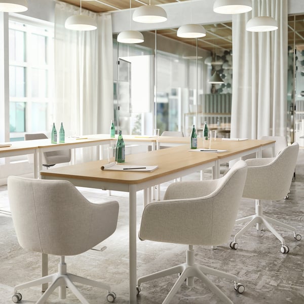 Modern minimalist office with light-wood tables, TOSSBERG chairs, large windows, and white pendant lights.