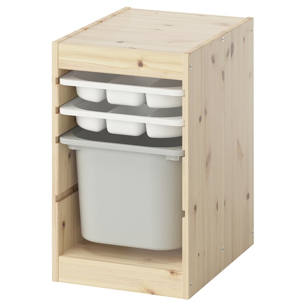 An ikea TROFAST light wooden storage unit with white plastic trays and buckets. It multiple compartments and shelves for organizing childrens items.