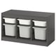 A TROFAST gray storage unit with white plastic bins, designed for children. It has a modern, organized look with adjustable compartments.