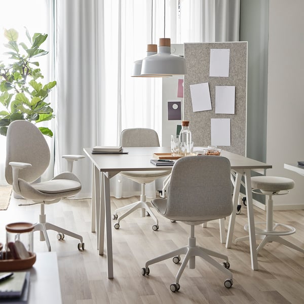 Modern office with TROTTEN desks and flintan chairs, a-shaped legs, hanging light.