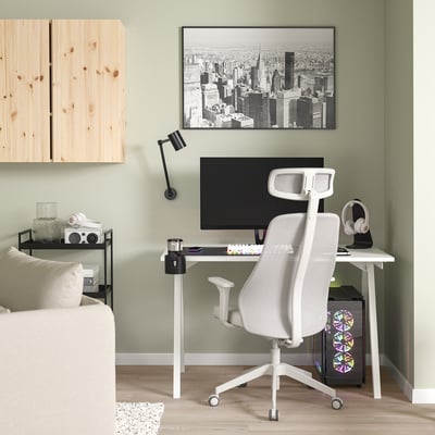 Minimalist home office: white gaming chair, compact desk, black monitor, cityscape photo.