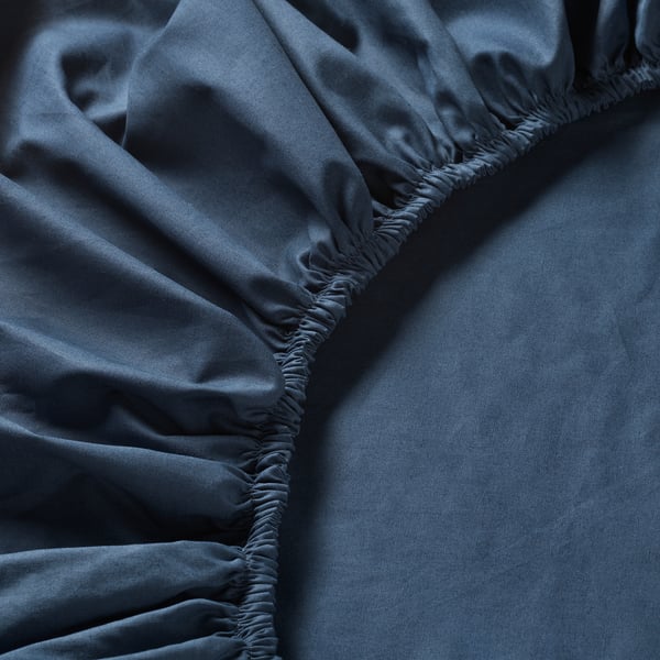 Dark blue bed sheet with subtle ruched elastic detail around hem.