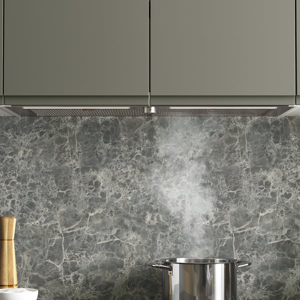 Modern kitchen with marble backsplash and wooden utensils.