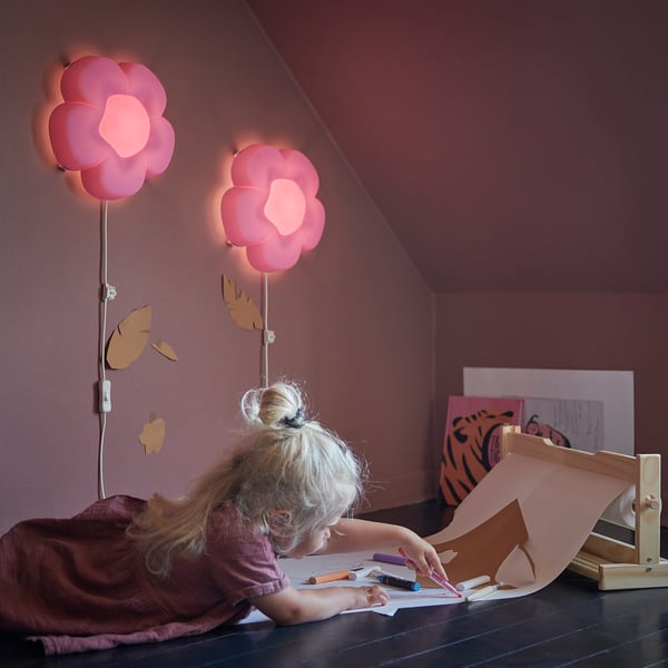Child drawing at table with pink flower lamps, UPPLYST.