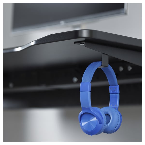 Bright blue headphones hang neatly from a sleek, black gaming desk with silver hooks.