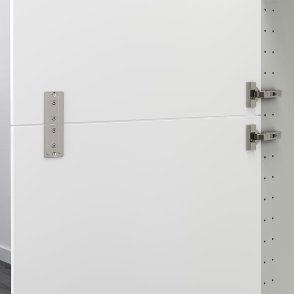 White cabinet rail connects two doors together.