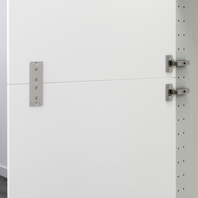 White cabinet rail connects two doors together.