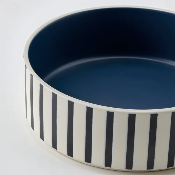 Round white bowl, blue inside, black stripes.