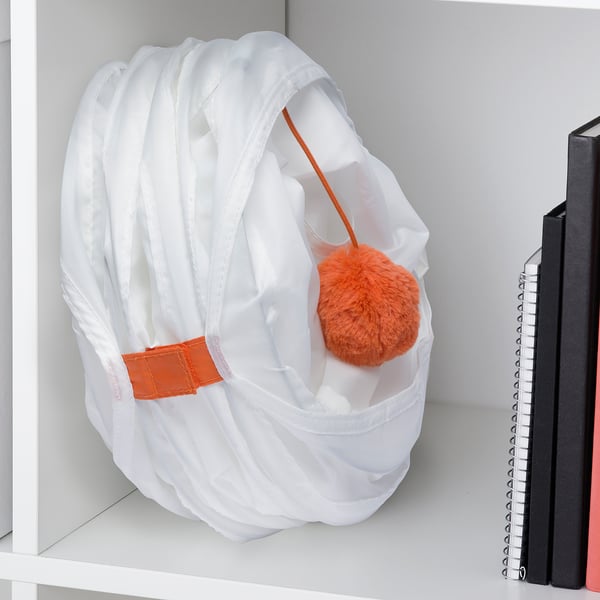 White cat play tunnel with orange accents on shelf.