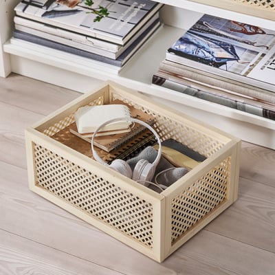 Light wooden crate with woven design holds headphones, books, and small items. Part of VÄLTNING series for organised storage.