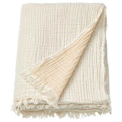 A VALLKRASSING cream-colored cotton throw blanket with a crinkled texture and raw fringe edges.