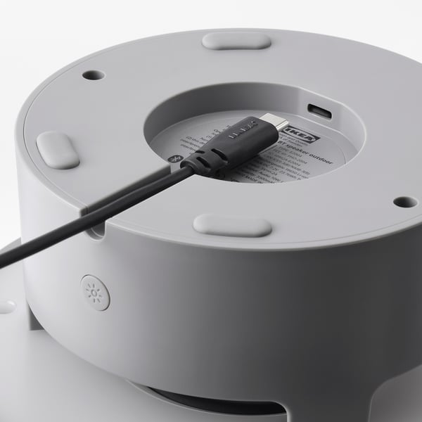 Image depicts the underside of a VAPPEBY speaker lamp, showing its charging port with a connected usb cable.