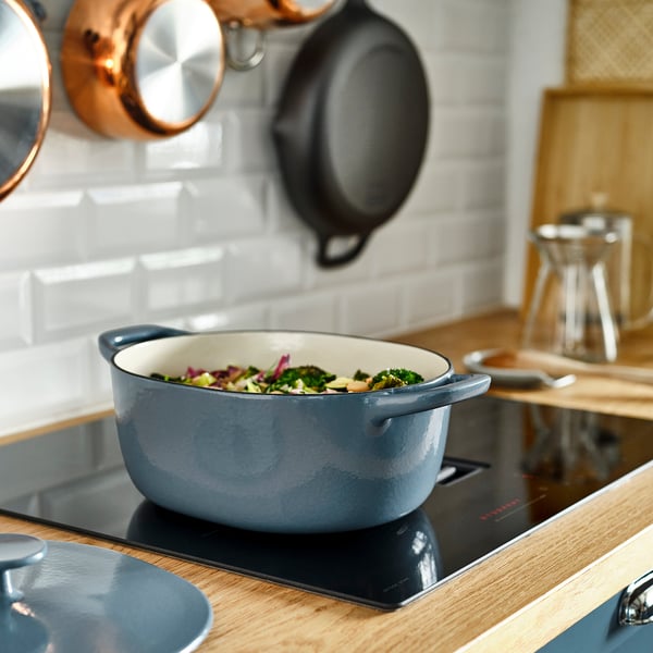 VARDAGEN cookware on modern stove with veggies; kitchen utensils on counter.