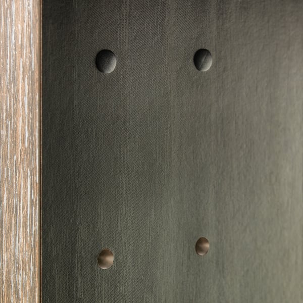 Four circular caps cover drill holes in a dark surface, making them less visible and giving a finished look.