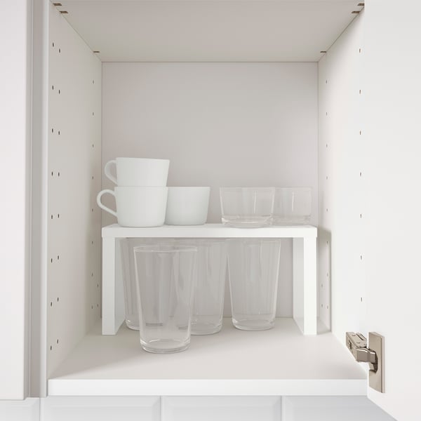 Kitchen cabinet shelf insert organises glasses and bowls, maximising storage space.
