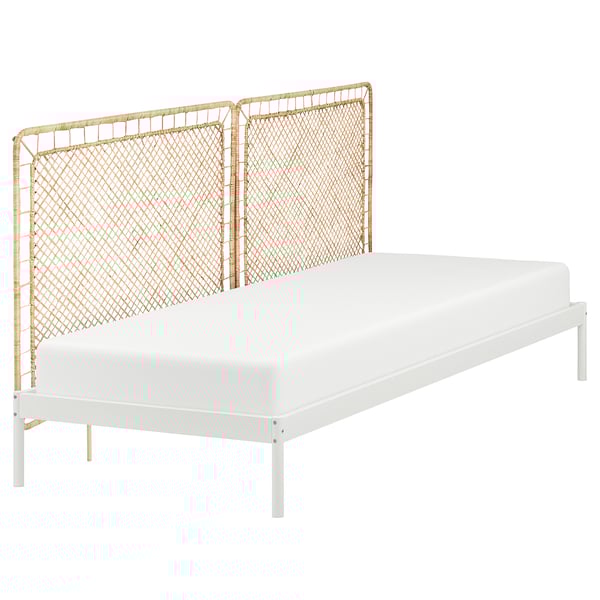 A VEVELSTAD bed with a white metal frame and natural rattan headboard, combining modern and natural elements.