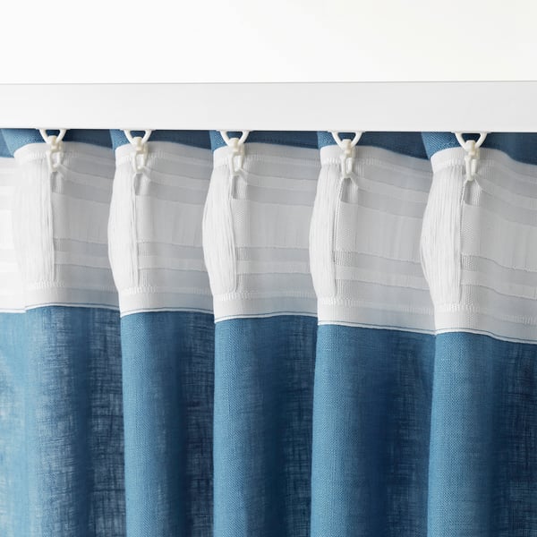 Curtain hooks hanging blue and white curtains.