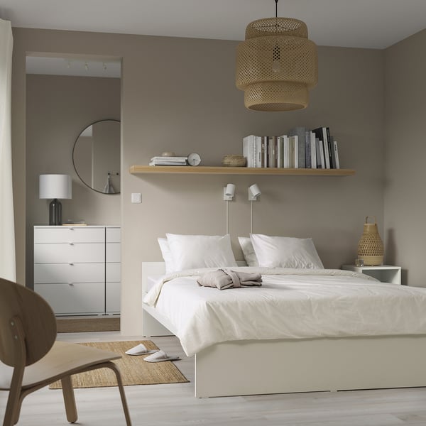 Bedroom with white VIHALS bed, crisp linens, wooden chair, and woven pendant light.