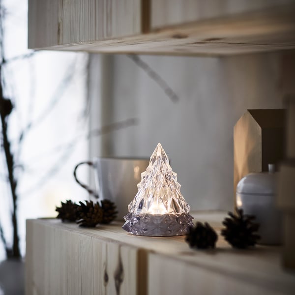 Small VINTERFINT tabletop light, clear, star-like shape, sits beside pinecones.