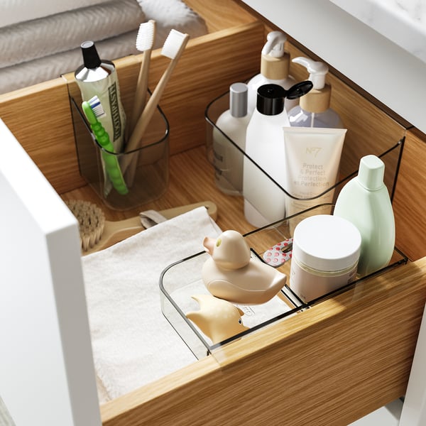 Bathroom drawer organiser with toothbrush holder, bottle, and tray.
