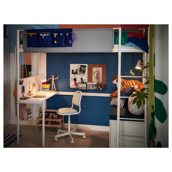 Childs bedroom with white bunk bed, study desk, and storage boxes. Blue wall, colourful decorations, and a plant.