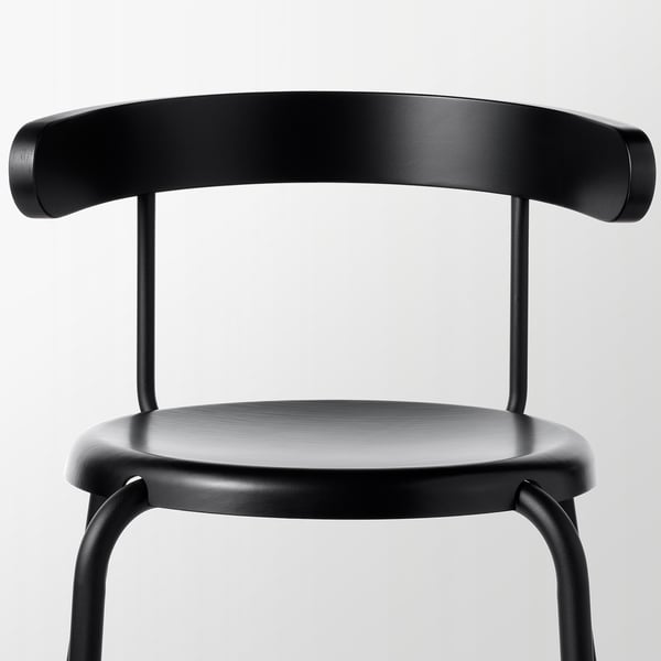Black chair with rounded back, smooth seat, sturdy metal legs.