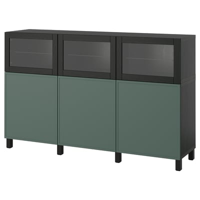 Ikea BESTÅ bortelis žalios ir tamsios spalvos. Jame yra stiklinės durys ir tvirtos durys, kurių viduje yra reguliuojamos lentynos.