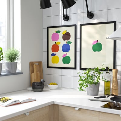 Moderni virtuvė su FISKBO obuolių paveikslėliu, minimalistiniu dekoru, augalais, kulinarijos knygomis.
