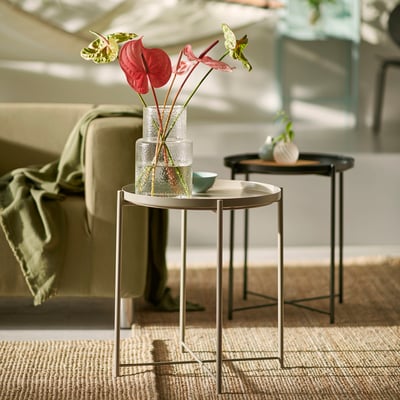Moderni svetainė su GLADOM šoniniais staliukais, vazomis, neutralia sofa ir kilimu.