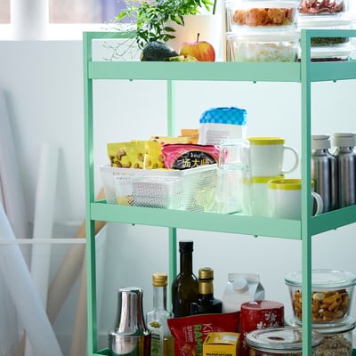 -pakopos IKEA lentyna su augalais, produktais, užkandžiais ir buteliais.