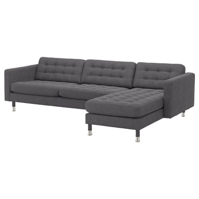 Šiuolaikinė pilka l formos sofa su tamsiomis kojomis ir kuokštelinėmis pagalvėlėmis.