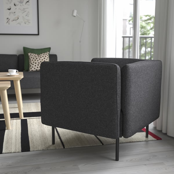 Moderni svetainė su tamsiai pilka lillehäm sofa, foteliais ir mediniu stalu. Jauki, šiuolaikiška aplinka.