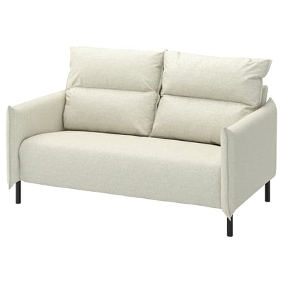 Šviesiai smėlio spalvos MANNARP sofa su moderniu, minimalistiniu dizainu ir aukštu atlošu, užtikrinančiu komfortą. Jis turi pliušines pagalvėles ir aptakias juodo metalo kojas.
