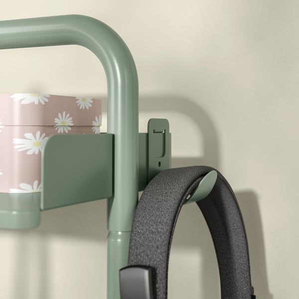 Žali RELATERA alkūniniai stalai stambiu planu, su rankena ir ramunėlių tematikos lentynos dalimi.