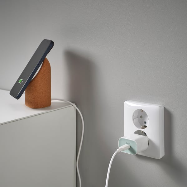 USB-c įkroviklis sieniniame lizde su įkrovimo laidu. Pabrėžia kompaktišką, greito įkrovimo dizainą.