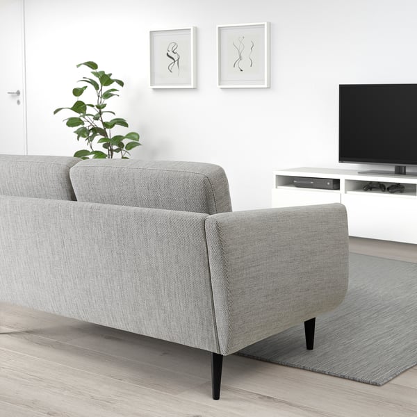 Moderni svetainė su sofa SMEDSTORP, televizoriumi, augalu ir minimalistiniu dekoru.