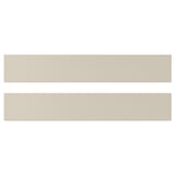 На изображении показаны две гладкие бежевые фасады кухонных шкафов HAVSTORP. Прямоугольная форма с четкими линиями.