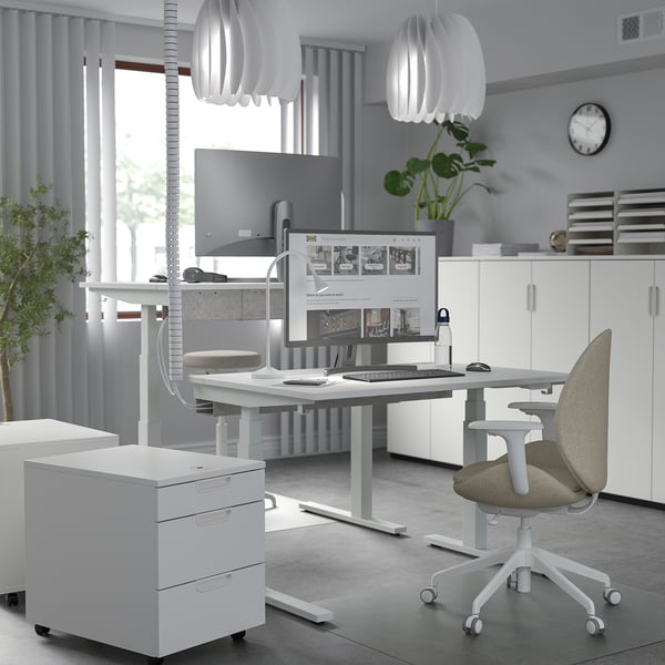 Современный домашний офис: белый стол MITTZON, широкий и высокий, с двумя моторами, эргономичным стулом, двойными мониторами и стильными подвесными светильниками.