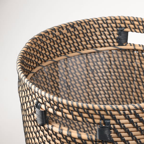 Замысловатая корзина с темными и светлыми полосами, прочными ручками, демонстрирующими высокое качество изготовления.