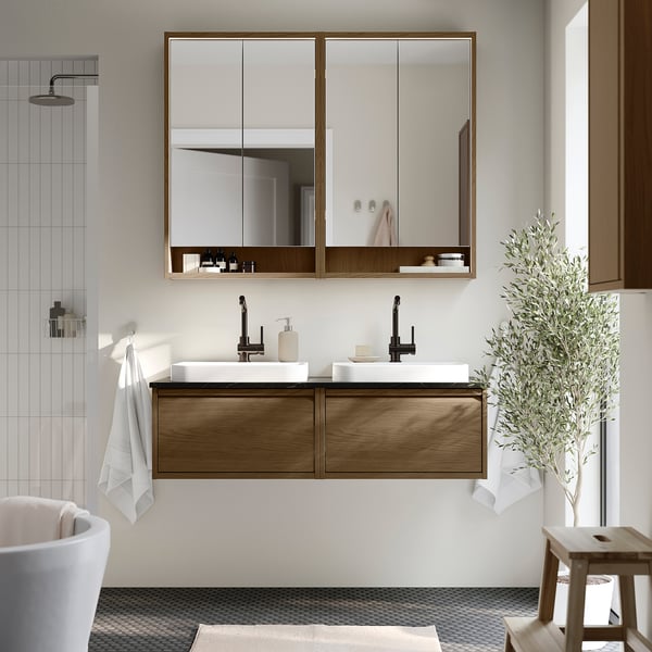 Modern bathroom with ÄNGSJÖN double vanity, two sinks, mirror cabinet, shower, stool, plant.