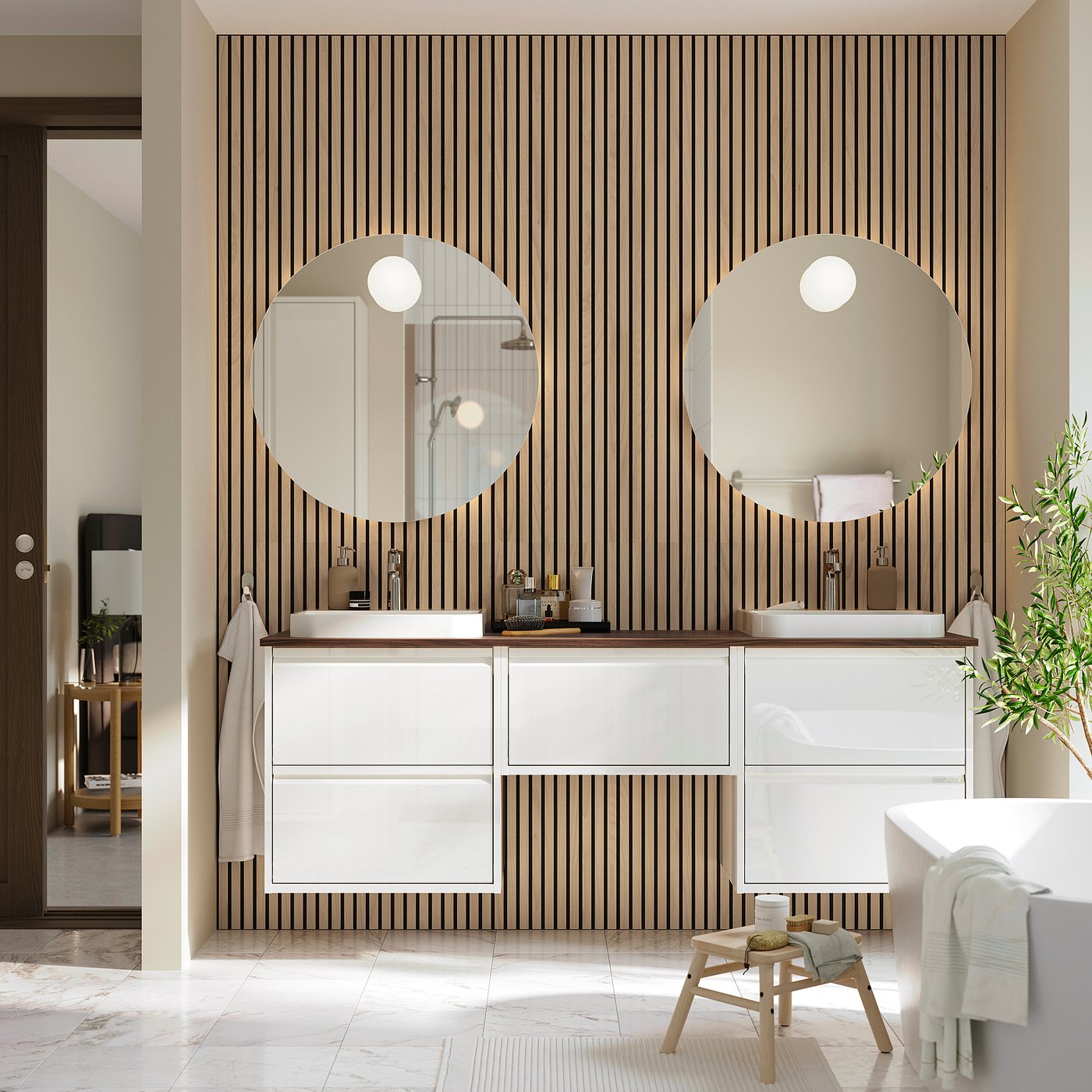 Modern bathroom with white ÄNGSJÖN vanity, dual sinks, mirrors, and bold wallpaper.