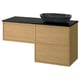 Modern bathroom setup featuring ÄNGSJÖN light wood vanity with black countertop and sink.