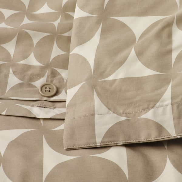 Close-up of a button on a duvet cover with a geometric pattern in gray-beige and off-white. The button is part of the duvet covers closure system.